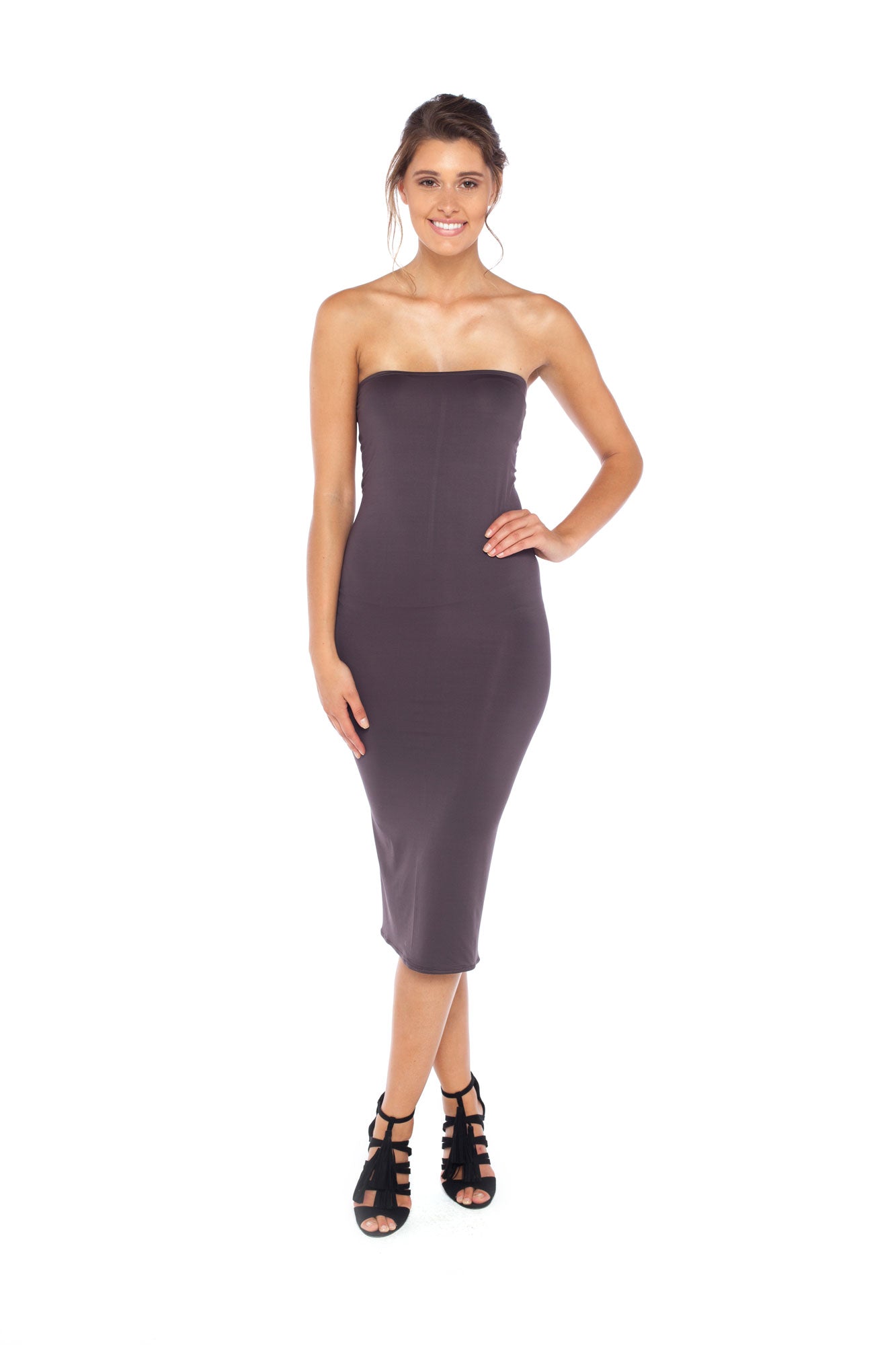 A woman with curvy hips wearing a strapless tube dress in khaki jersey. The tube dress is designed in Australia and styled with heels as a slinky girls-night-out evening dress.