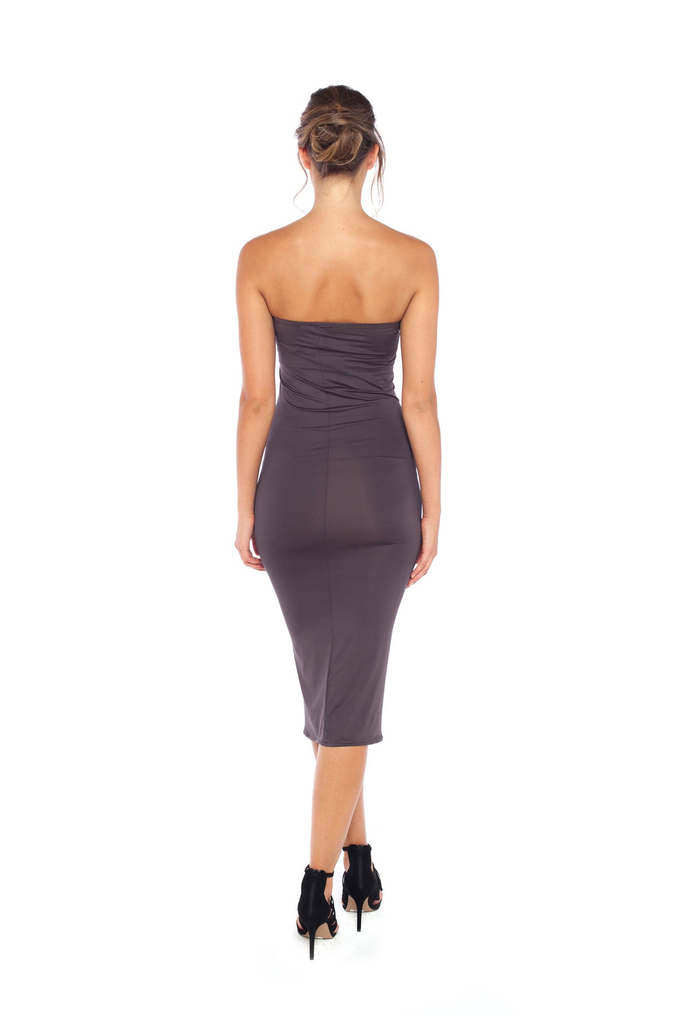 A woman with curvy hips wearing a strapless tube dress in khaki jersey. The tube dress is designed in Australia and styled with heels as a slinky girls-night-out evening dress.