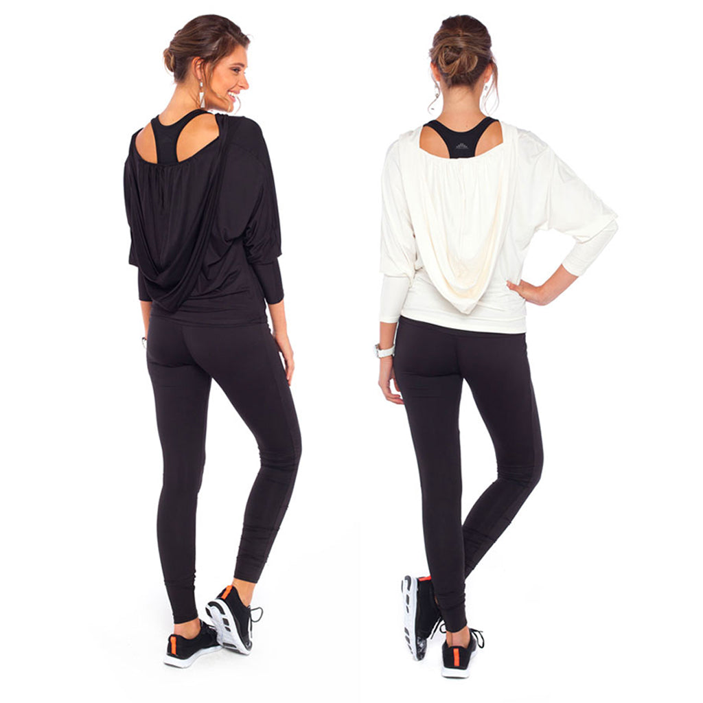 Two women wear Australian and New Zealand women's leisurewear clothing brand, Urban Silk's Batwing Sleeve hooded Tops and Skinny Black legging-style pants for leisure and activewear. One hooded top is black jersey, the other women's leisurewear top is ivory jersey.