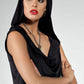 A woman wears an elevated hoodie top in black slinky jersey. Crossing leisurewear and evening wear, the draped hooded top, features an oversized hoodie back and a cowl neck to the front. Worn with the hood up, this leisurewear top elevates for sophisticated evening glamour. Shop online at Urban Silk leisurewear Australia.