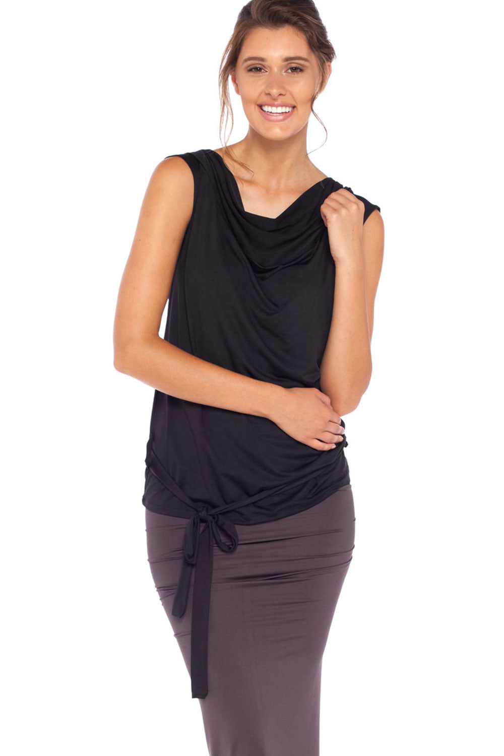 A woman wears a black, sleeveless hooded top with cowl neck and belt ties by Australian leisurewear brand, Urban Silk. Showing an oversized hood, this elegant top drapes in slinky jersey to give an elevated leisurewear look. Click to shop in Urban Silk's clothing boutique.