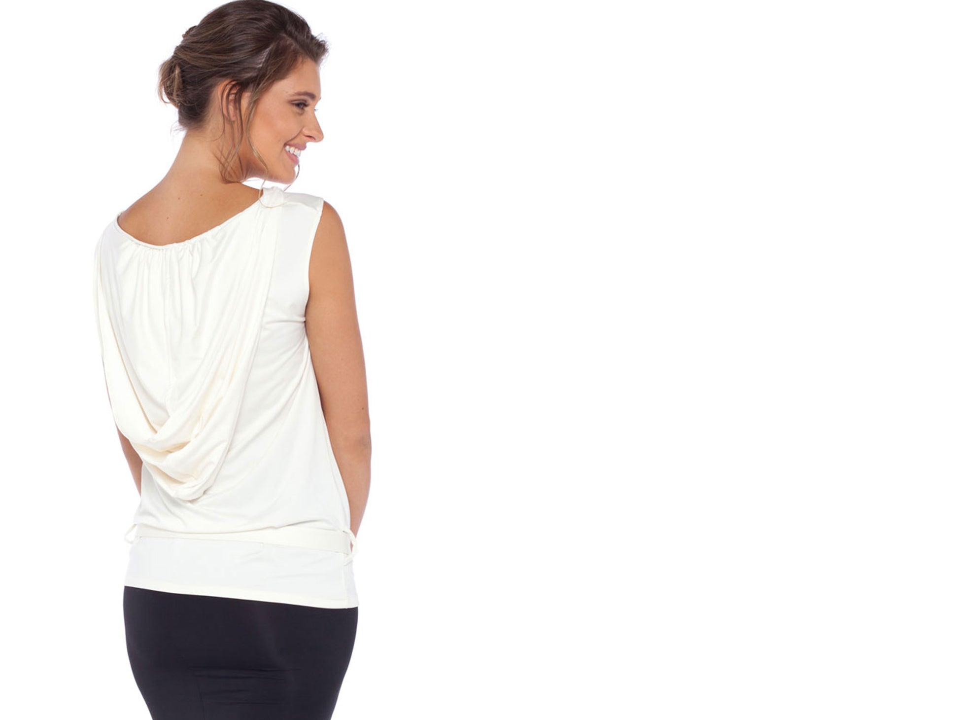 A woman in a sleeveless hooded top in ivory jersey, peeks over her shoulder as she revels in the comfort of this elegant hoodie top. For women's elevated leisurewear and hoodie tops for work, travel tops and comfortable casual tops Australia, it's got to be Urban Silks leisurewear lifestyle clothing.  