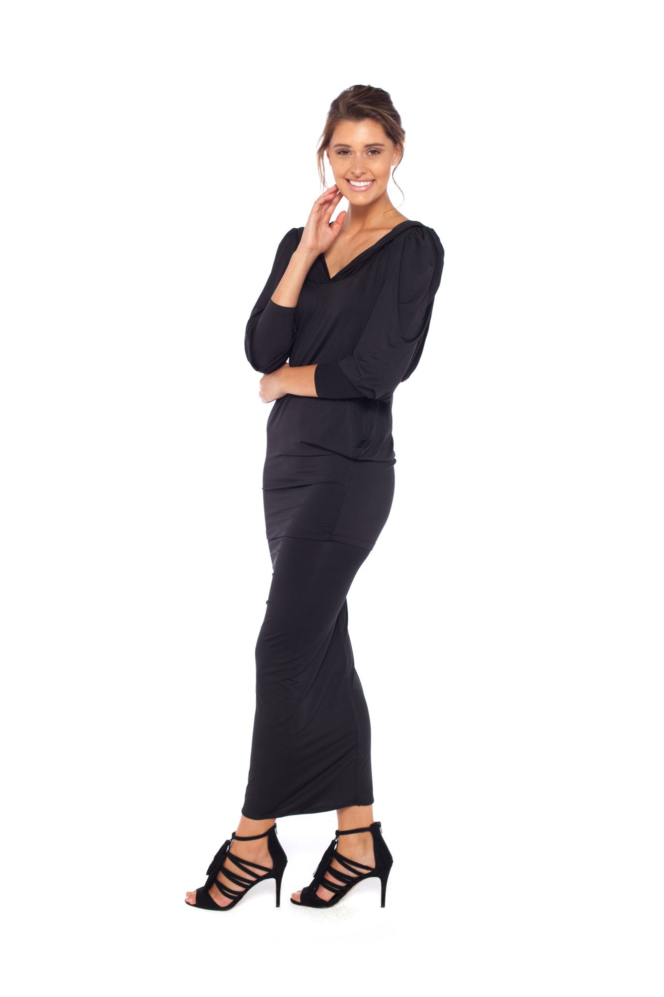 A woman wears a long sleeve hoodie top in black slinky jersey. The hoodie sweatshirt is worn with a black slinky jersey tube skirt worn as a maxi skirt and styled for evening as a going out dress. Both hoodie top and tube skirt are by Australian fashion brand, Urban Silk who specialise in leisurewear clothing for women's capsule work wardrobes.