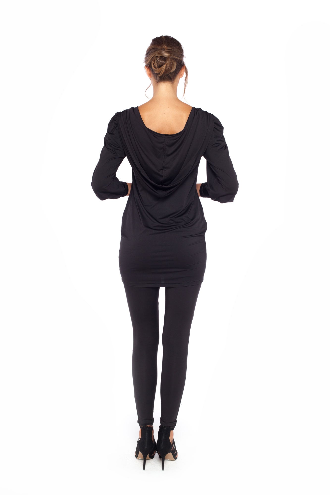 Back view of a woman wearing a long sleeve hoodie top in black slinky jersey. The hoodie sweatshirt is worn with black legging pants. Both hoodie top and legging pants are by Australian fashion brand, Urban Silk who specialise in leisurewear clothing women can wear for work, travel and casual wear.