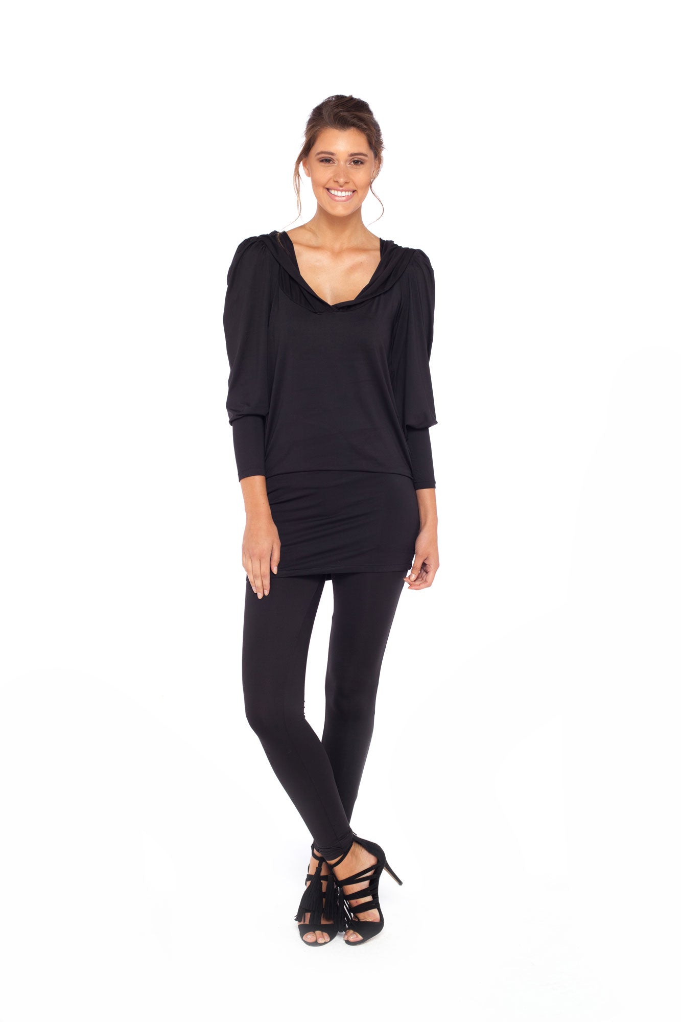 A woman wears a long sleeve hoodie top in black slinky jersey. The hoodie sweatshirt is worn with black legging pants. Both hoodie top and legging pants are by Australian fashion brand, Urban Silk who specialise in leisurewear clothing women can wear for work, travel and casual wear.