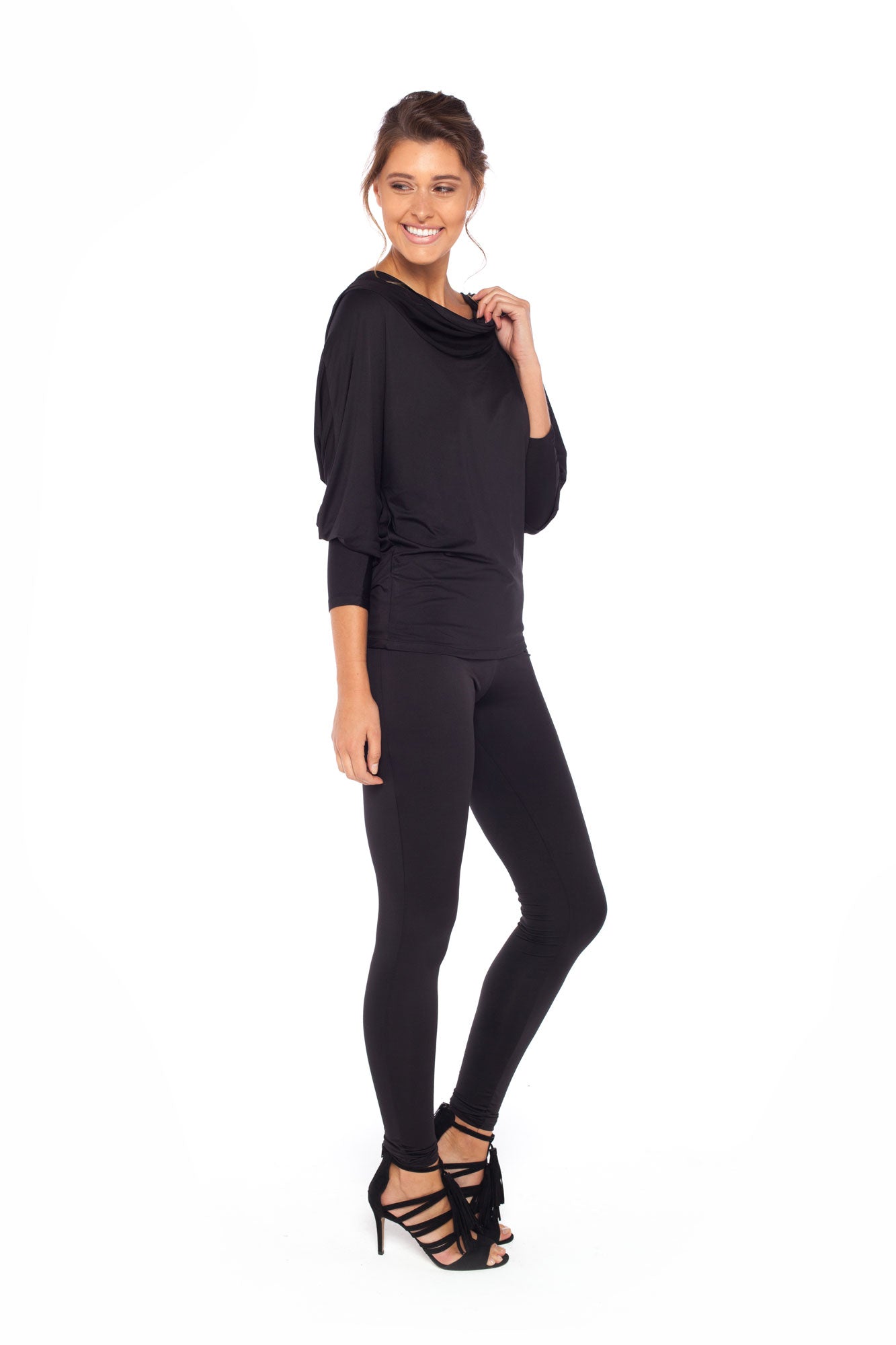 Woman wearing black jersey hooded top with batwing sleeves worn with black slim leg legging pants and styled with heels for work style or low-key evening glamour. shop jersey tops and pants designed in Australia for petite to plus size women.