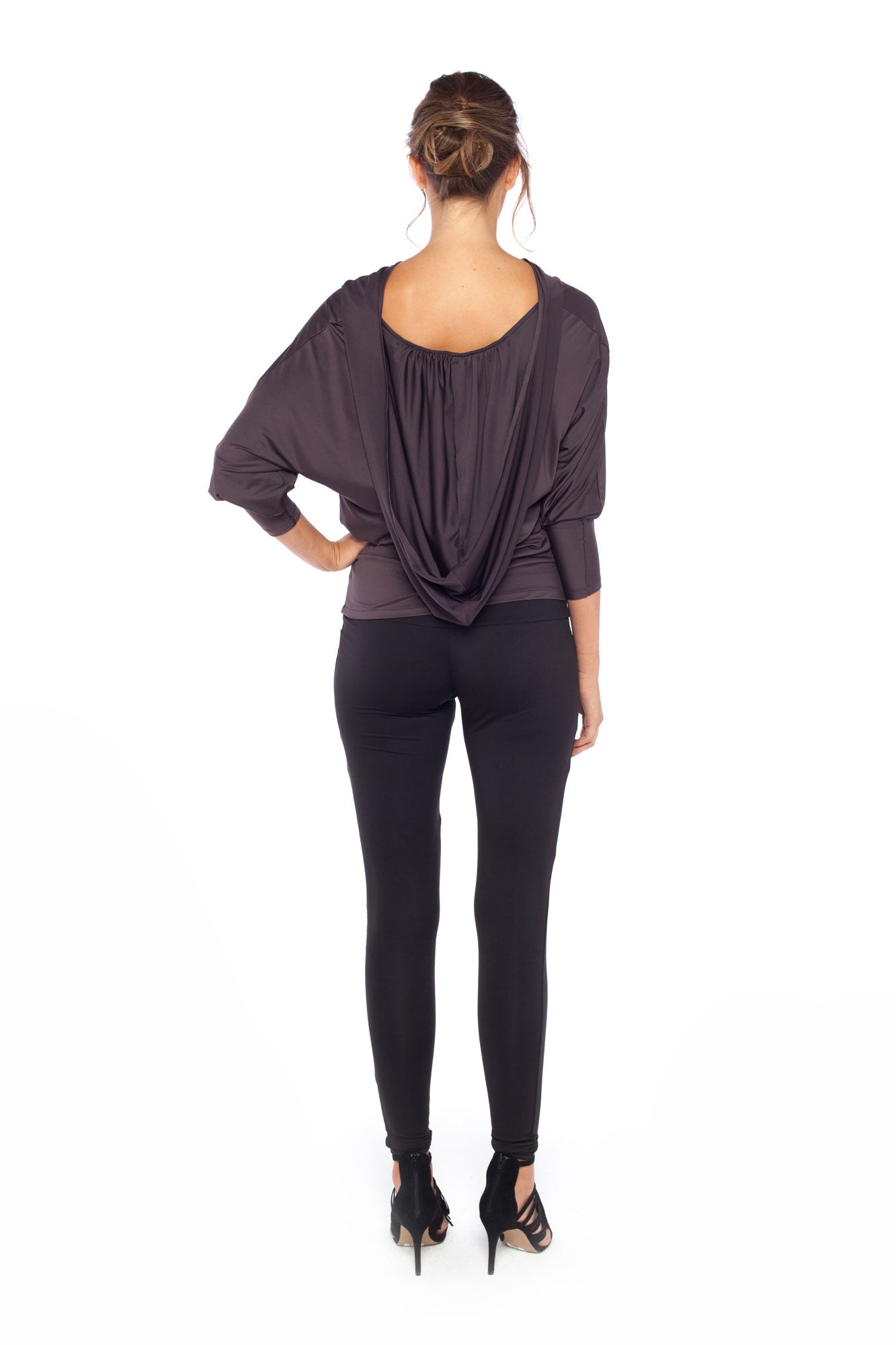 Woman wearing a hooded top in slinky jersey with batwing sleeves worn with slim-leg, long-length, black legging trousers and styled with heels for work wear style or low-key going out style. Designed in Australia and made for petite to plus size women