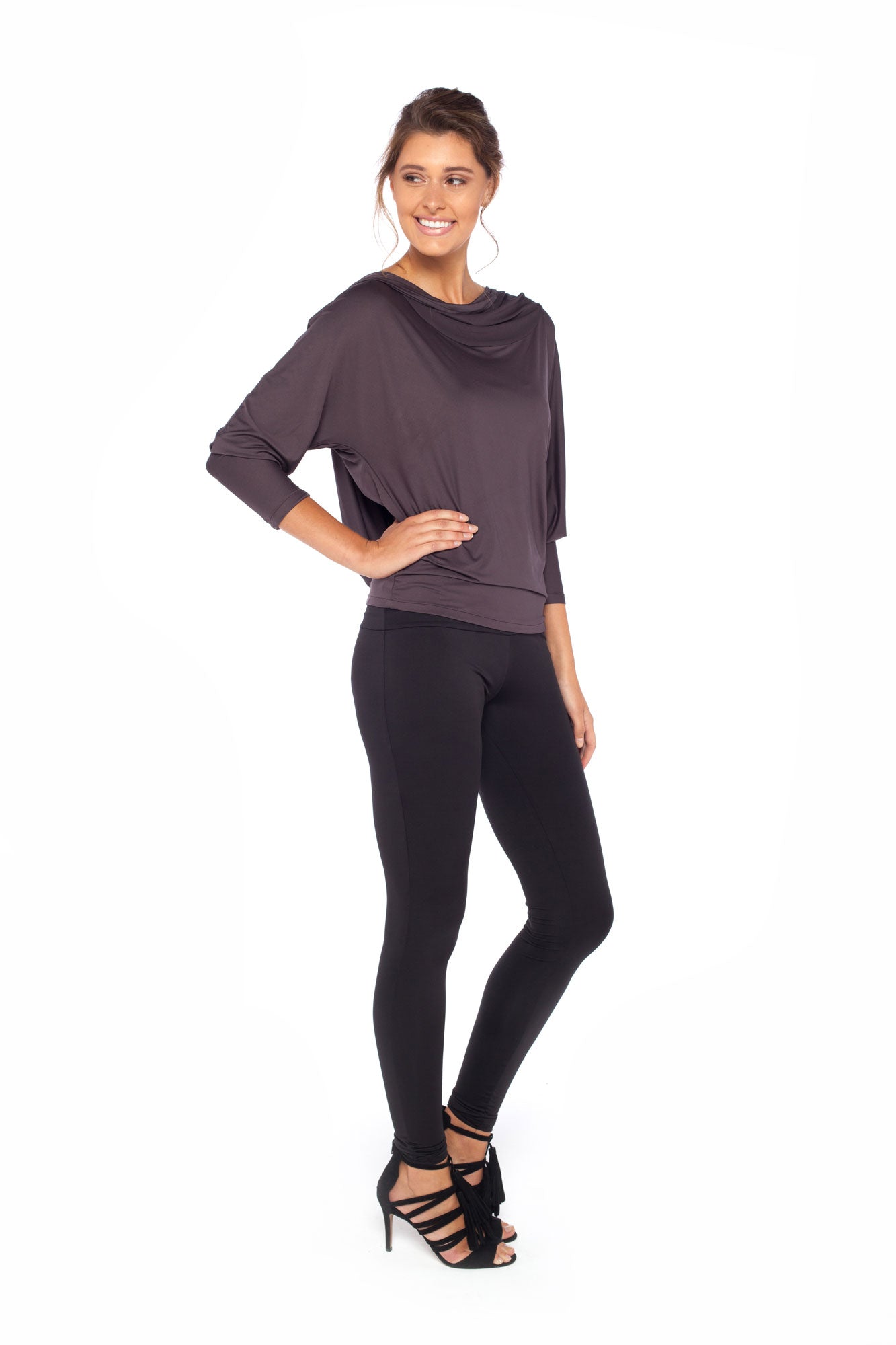 Woman wearing a hooded top in slinky jersey with batwing sleeves worn with slim-leg, long-length, black legging trousers and styled with heels for work wear style or low-key going out style. Designed in Australia and made for petite to plus size women