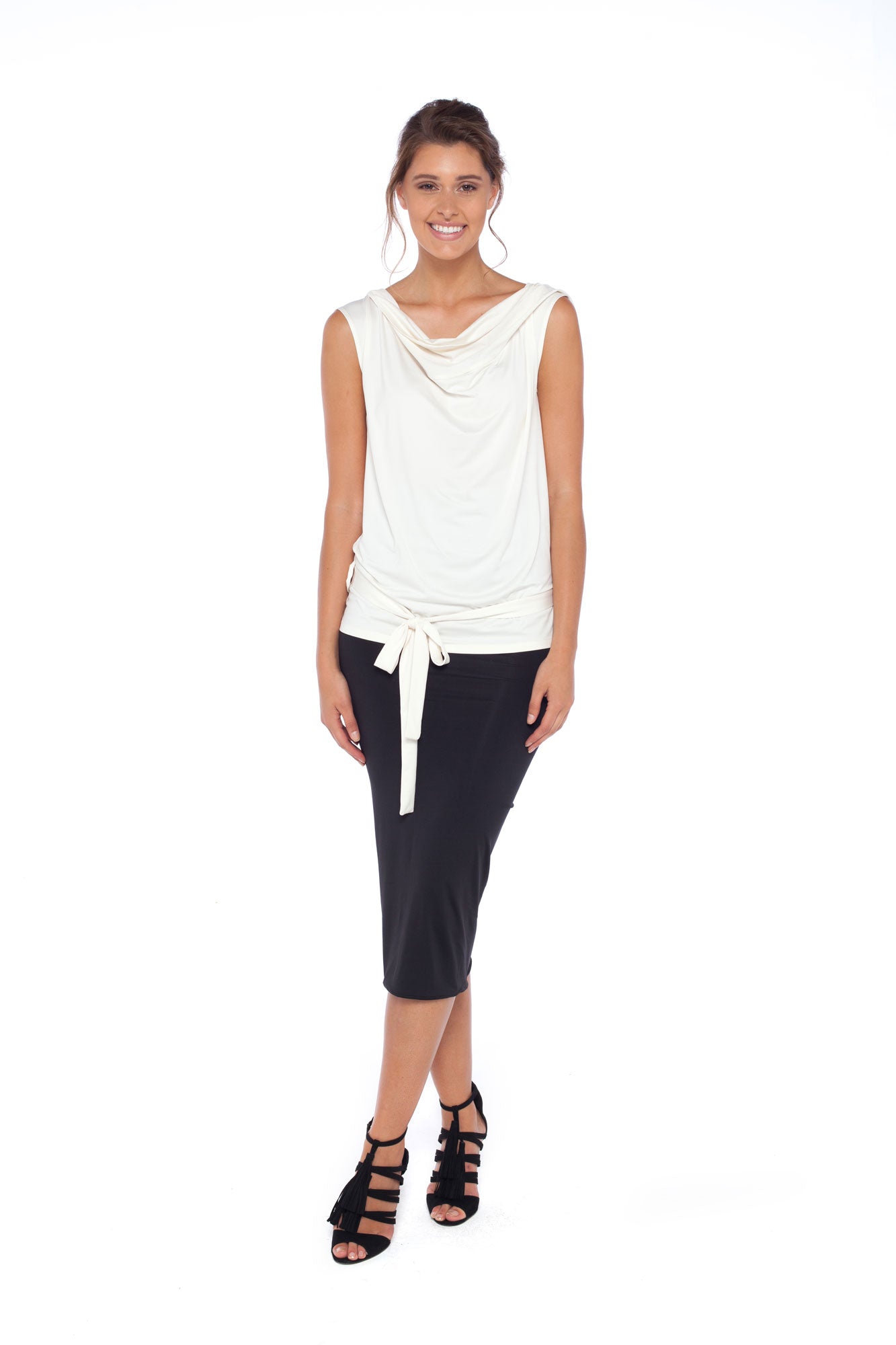 A woman wearing Australian leisurewear brand Urban Silk's Sleeveless Hooded jersey Top in Ivory and a black jersey pencil skirt. Shop easy care work tops for the young professional women and easy travel clothes online at Urban Silk clothing and feel as good as she looks!