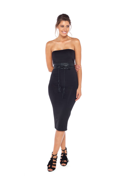 A woman wearing a strapless black tube dress in silky jersey. The dress is styled with a belt to define the curves of women's bodies and worn with high heels for an evening wear look. Designed in Australia by Urban Silk leisurewear.