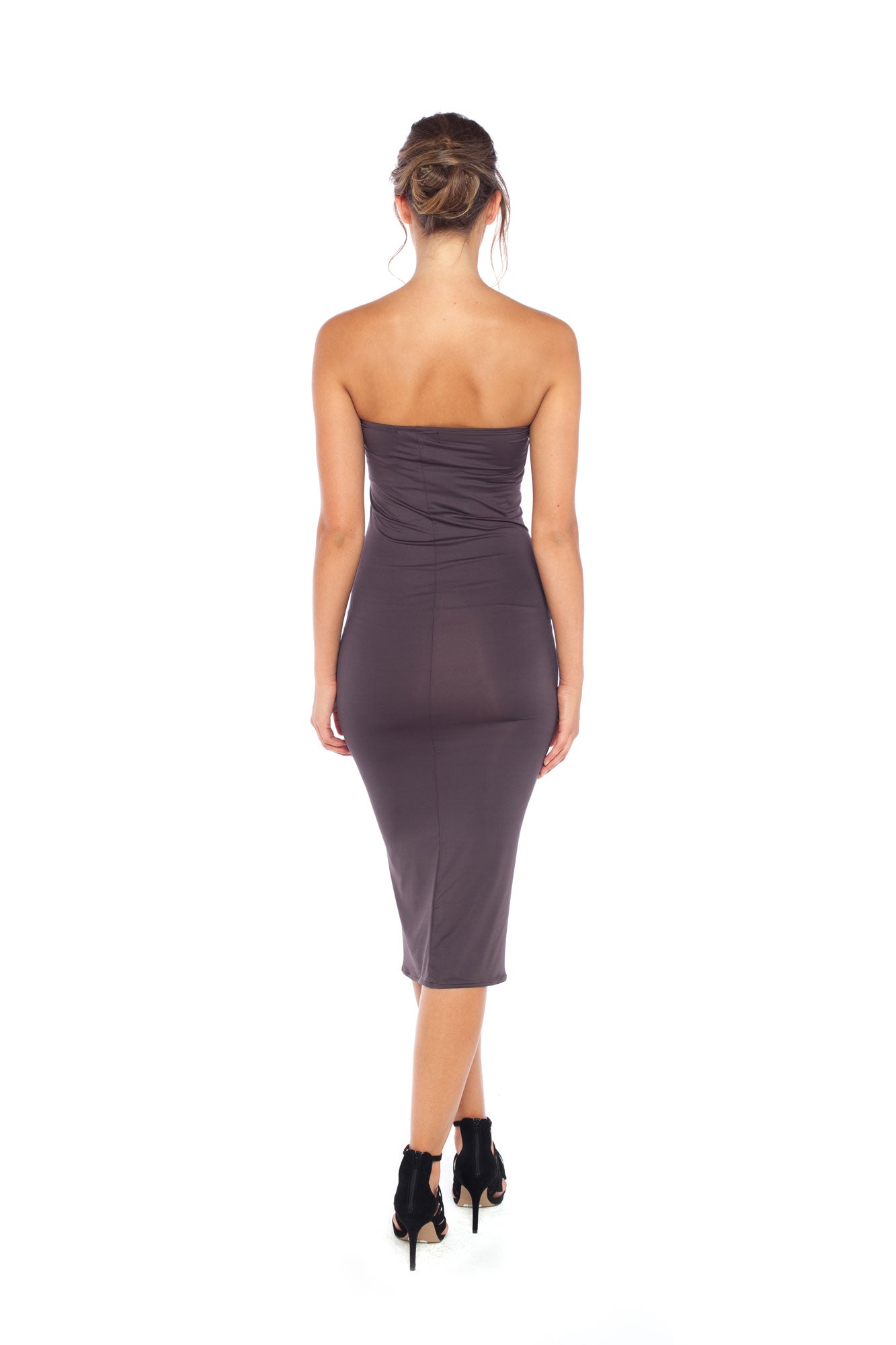 A woman with curvy hips wearing a strapless tube dress in khaki jersey. The tube dress is designed in Australia and styled with heels as a slinky girls-night-out evening dress. 